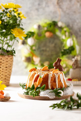 Easter lemon cake with icing and easter decoration. Easter gugelhupf cake with marzipan carrots and chocolate easter bunny