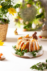 Easter lemon cake with icing and easter decoration. Easter gugelhupf cake with marzipan carrots and chocolate easter bunny