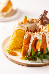 Easter lemon cake with icing and easter decoration. Easter gugelhupf cake with marzipan carrots and chocolate easter bunny