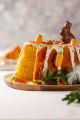 Easter lemon cake with icing and easter decoration. Easter gugelhupf cake with marzipan carrots and chocolate easter bunny