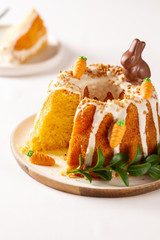 Easter lemon cake with icing and easter decoration. Easter gugelhupf cake with marzipan carrots and chocolate easter bunny