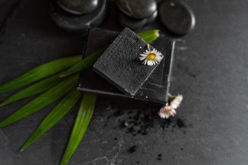 black carbon charcoal soap on a black stone background 