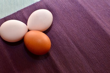 Three eggs on purple cloth 