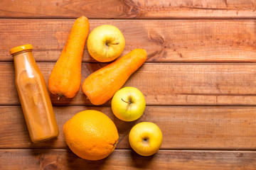 diet on juices, freshly squeezed juice from apples, carrots, orange on a wooden table, juice for weight loss, the concept of a vegan diet on fruits for health and beauty
