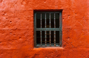 Window against a orange plaster facade in the Santa Catalina Convent of Arequipa, Peru.