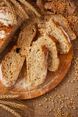 Sliced wholegrain bread on wooden board.  Top view