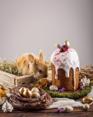 Easter cake with gold eggs and little rabbit near on wood table