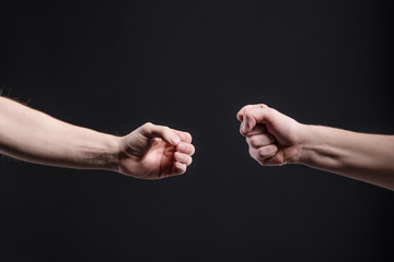 Men's hands on a dark background, show a game of stone, scissors, paper. The concept of...
