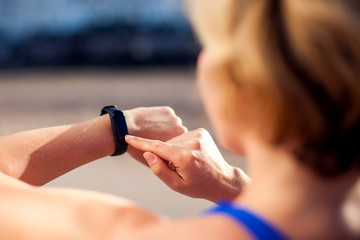 Woman training with fitness watch outdoor. People, technology and healthcare concept