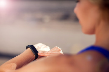Woman training with fitness watch outdoor. People, technology and healthcare concept