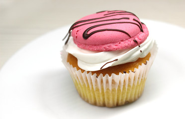 Chocolate muffin cake with cream and pink marshmallows decorated with chocolate