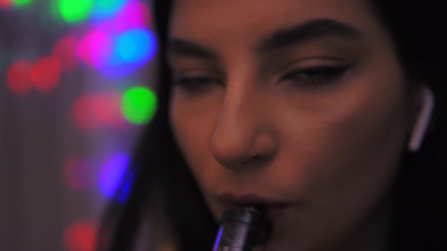 Vaping beauty young girl smoking e-cigarette vape smoke inhaling, slow motion
