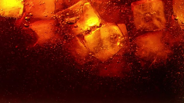 Super slow motion of pouring cola drink with ice cubes inside. Filmed on high speed cinema camera, 1000 fps.