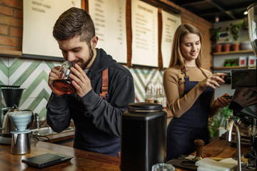 Portrait of two young and successful barista working on coffee shop, making coffee together