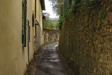 Old narrow alley and stone wall in outskirs of Florence