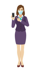 Businesswoman with medical mask pointing at a mobile phone. Full length portrait of businesswoman in a flat style.