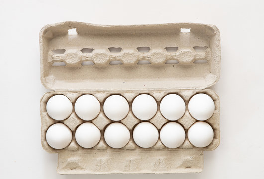 A Dozen Eggs In A Carton Isolated On White Background