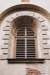 Obraz premium Old arched window with wooden shutters. Armenian Church, Lviv.