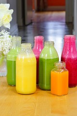 Glass bottles filled with colorful homemade fruit juice and smoothies
