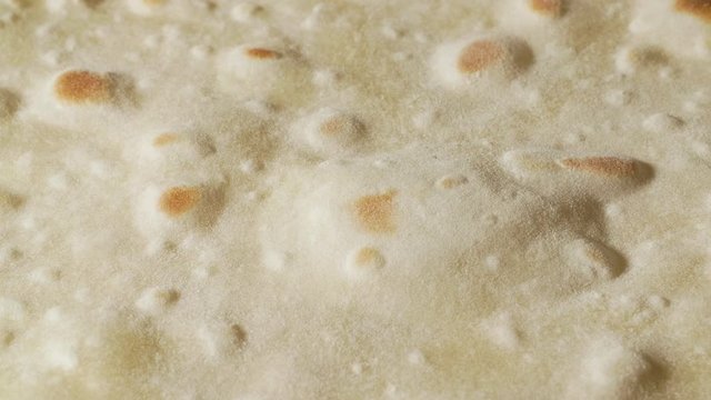 Traditional pita bread inflates with the bubble on the pan