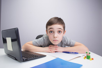 schoolboy studying homework math during his online lesson at home, social distance during quarantine, self-isolation, online education concept