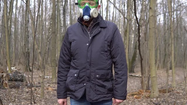 covid19 a man walks in a gas mask in the forest and in safety glasses