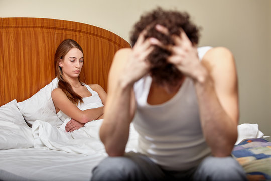 Family conflict. Young couple quarrels in bedroom at home.  Selective focus on woman