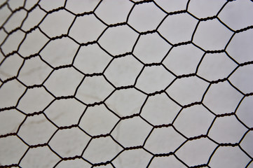 Texture of a metal fence forming hexagons (chicken coop mesh)