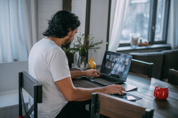 Fototapeta na wymiar Workplace at home. A man works at a laptop at home