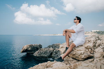 Fototapeta na wymiar A man on the rocks overlooking the sea