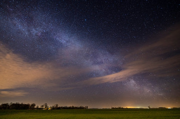Naklejka na ściany i meble Landscape at night, sky full of stars over an open field (high ISO photography)