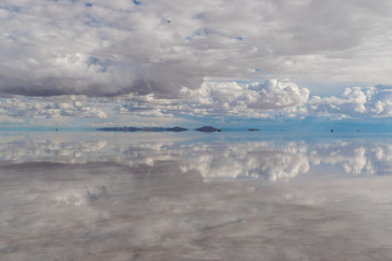 Naklejka na ściany i meble Dramatic landscape in the Uyuni wage, with the mirror effect, an effect that occurs in the February season where it is the rainy season.