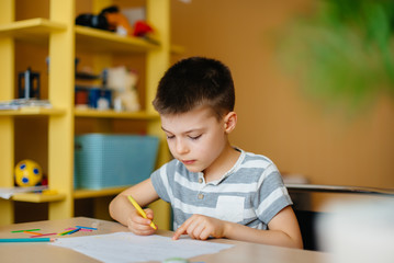 A school-age boy does homework at home. Training at school