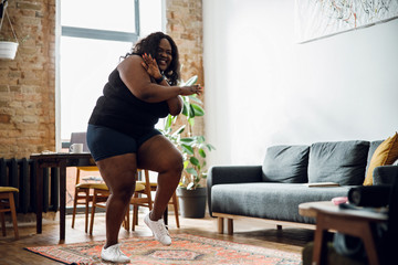 Positive plus size woman dancing at home stock photo
