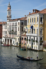Fototapeta na wymiar Venice canal with buildings on background and only one gondola on the water 