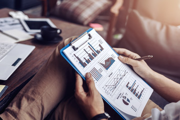 Businessman hold pen and working calculate data. document graph chart and report marketing....
