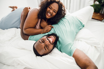 Laughing couple on the white bed stock photo