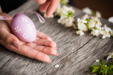 Egg on wooden background in human hands. Easter. Eggs. Bunny. Painted eggs. Holy day. People. Religion.