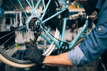 Close up of mechanic repairing bicycles in a workshop..