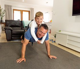 COVID-19 Outrbreak. Father and son exercising together at home during coronavirus quarantine