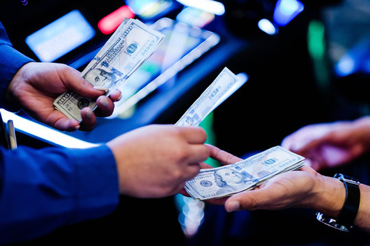hands paying dollar bills casino