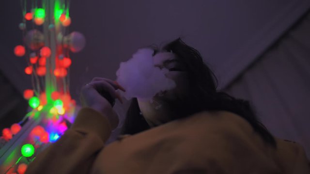 Girl smoking vape, vaping girl inhaling an e-cigarette vaping device