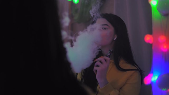 Sexy girl smoking vape looking at mirror, e-cigarette