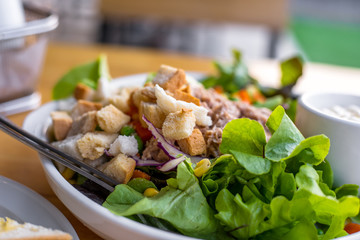 salad with tuna, salad dressing in bowl on the table.