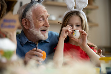 Happy elderly man preparing for Easter with granddaughter stock photo