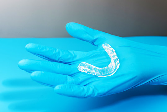Dentist holds occlusal splint used to reduce nighttime bruxism.