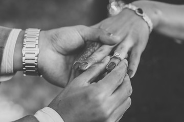 A couple's exchanging wedding rings close up hands