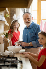 Mirthful man cracking eggs and smiling stock photo