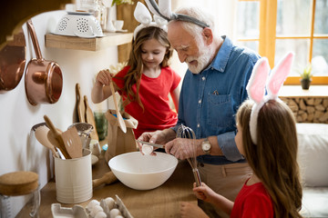 Cute children helping grandpa with cooking stock photo