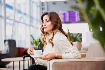 Attractive young woman holding cup of coffee